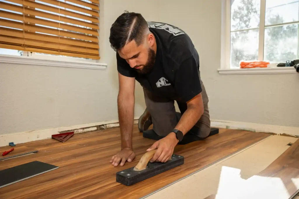 Installer using tapping block on wood flooring installation