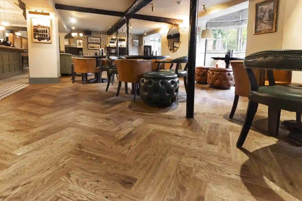 Rustic oak herringbone parquet flooring in traditional pub interior